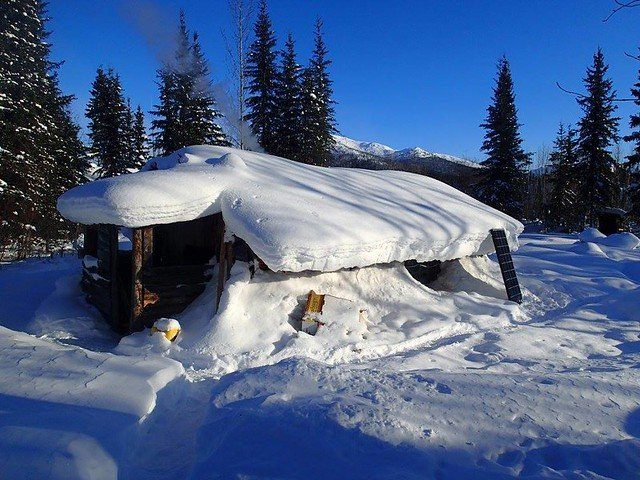 alaskan cabin covered in snow